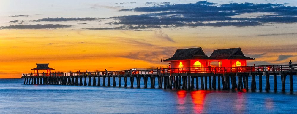 Naples Pier glowing after sundown over the Gulf