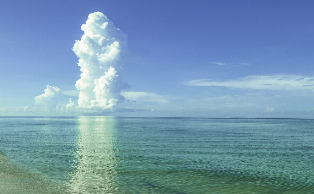 Calm turquoise water and towering clouds at Vanderbilt Beach, Naples